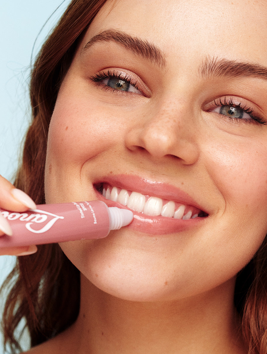 Model applying Lanolips Tinted Lip Balm SPF30 Perfect Nude