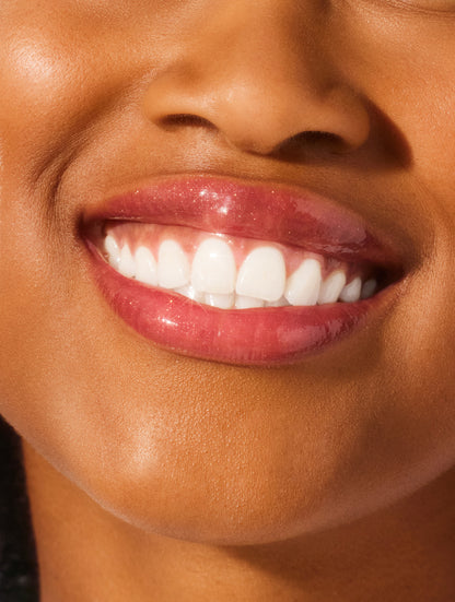 Close up image of a model lips wearing lanolips glossy balms candy lip balm.