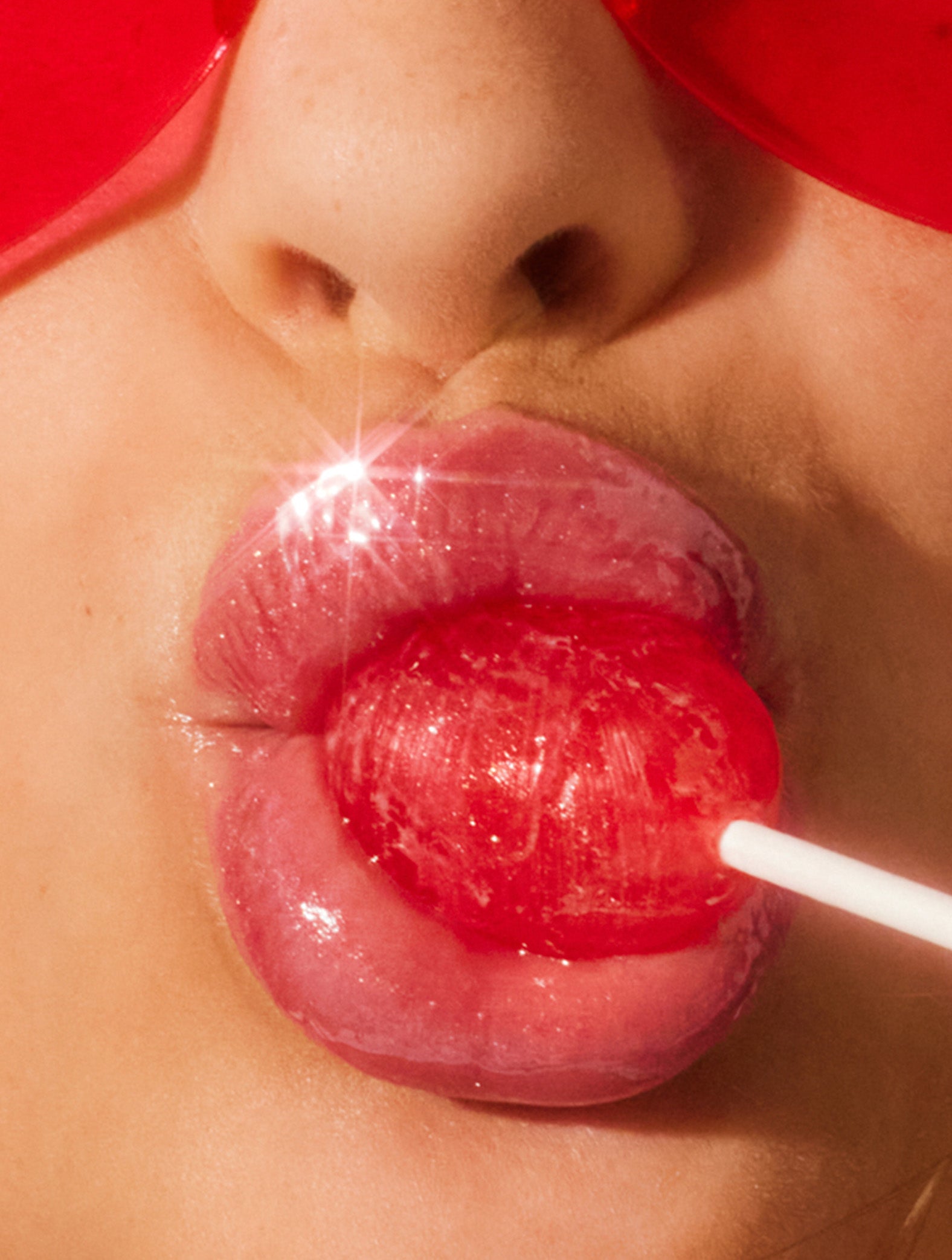 Close up image of a model wearing lanolips glossy balms candy lip balm.