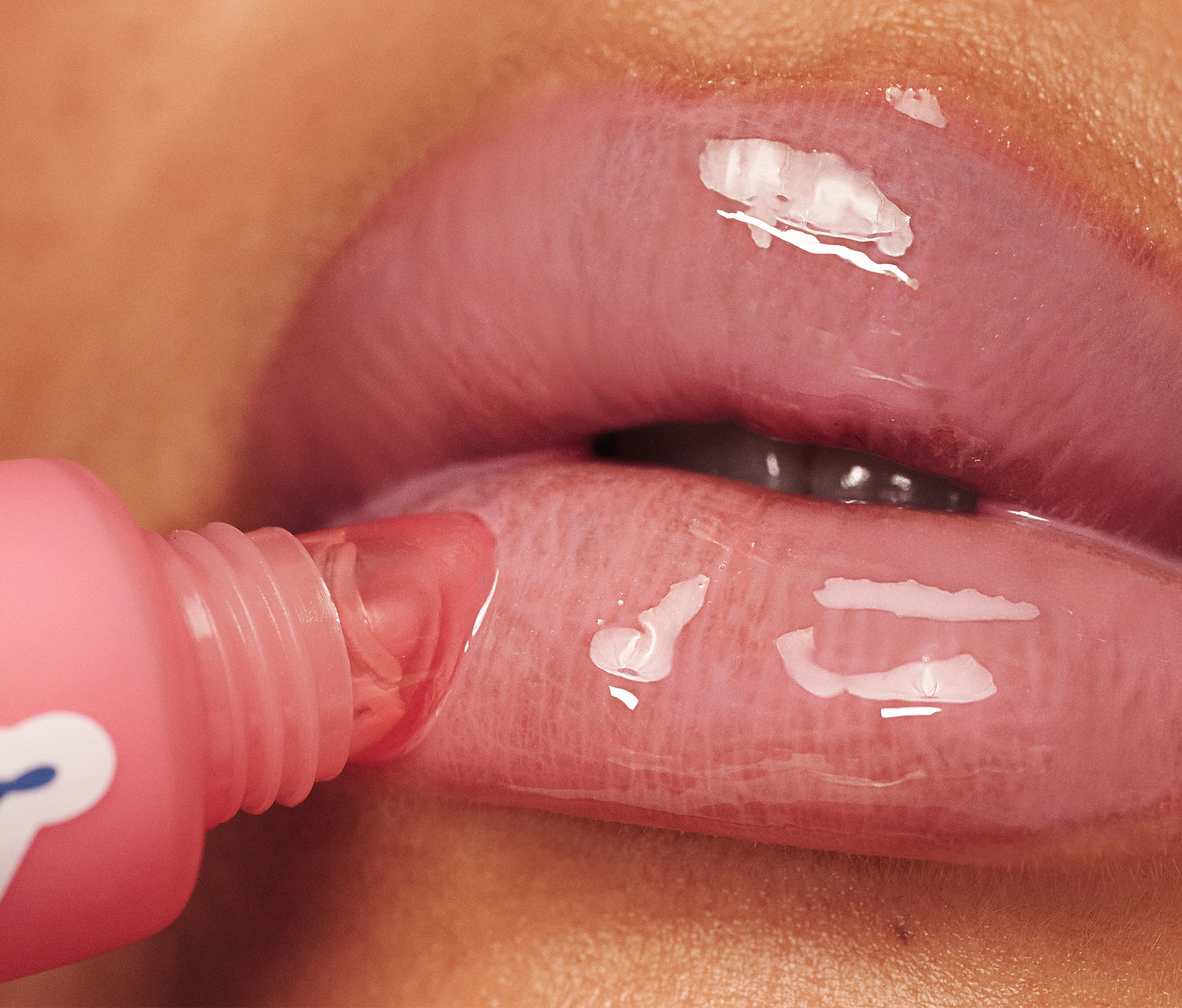 Extreme close-up of Lanolips Milkshake Ceramide Balm in Strawberry Bubble being applied to lips, creating a glossy, hydrated finish with a soft pink tint.