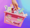 Assorted Lanolips lip balm tubes in a pink shopping basket against a gradient background